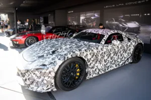 Kamuflaažiga varjatud Lexus LFA Concept prototüüp autonäitusel teiste võidusõiduautode taustal