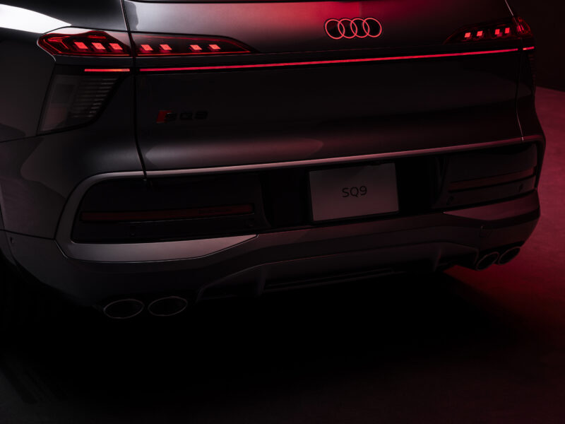 Audi SQ9 tagaosa detailvaade punases stuudiovalguses koos valgustatud Audi logo ja SQ9 tähisega
