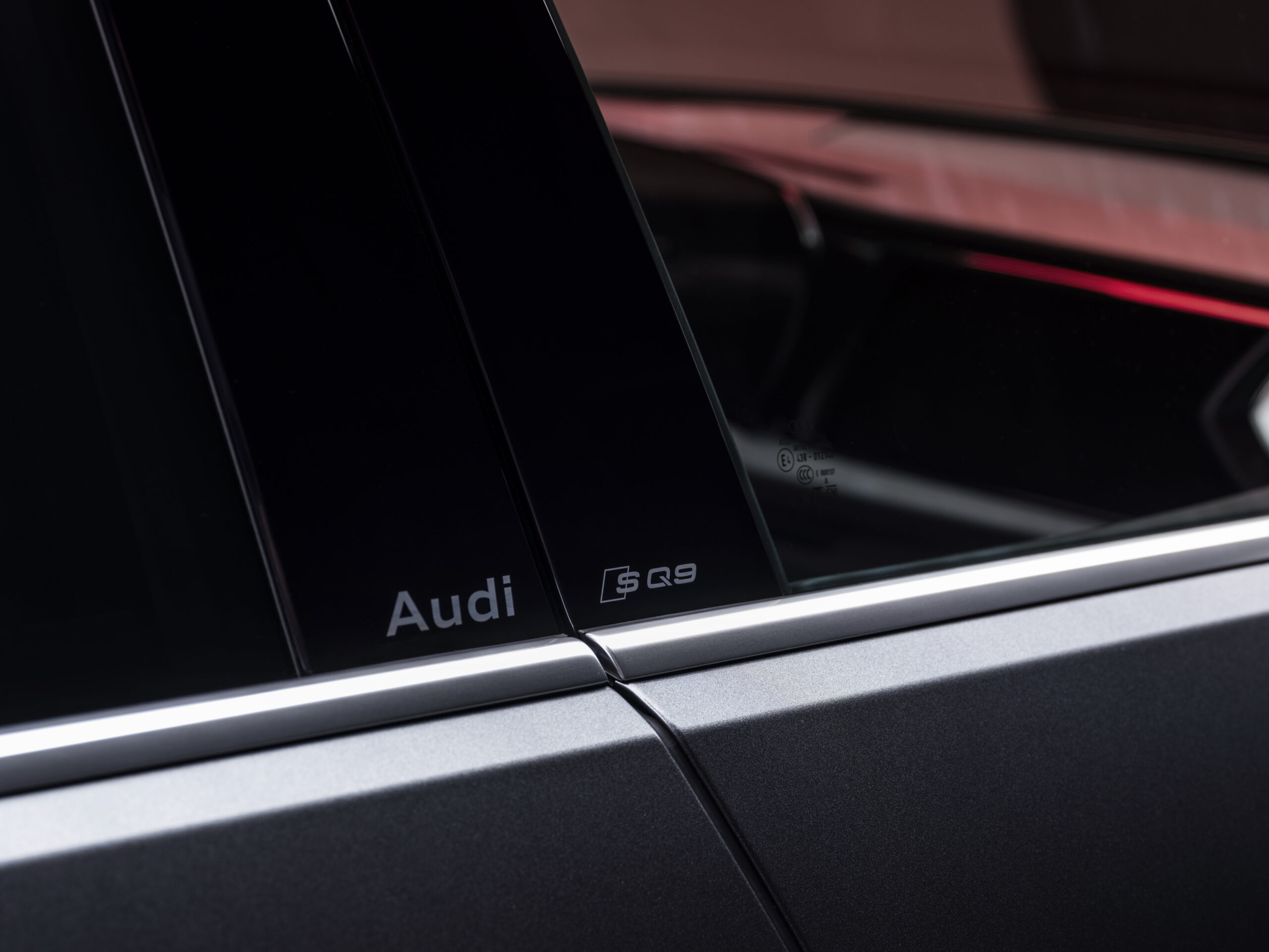 Audi SQ9 ukseposti detailvaade koos Audi ja SQ9 logodega B-piilaril