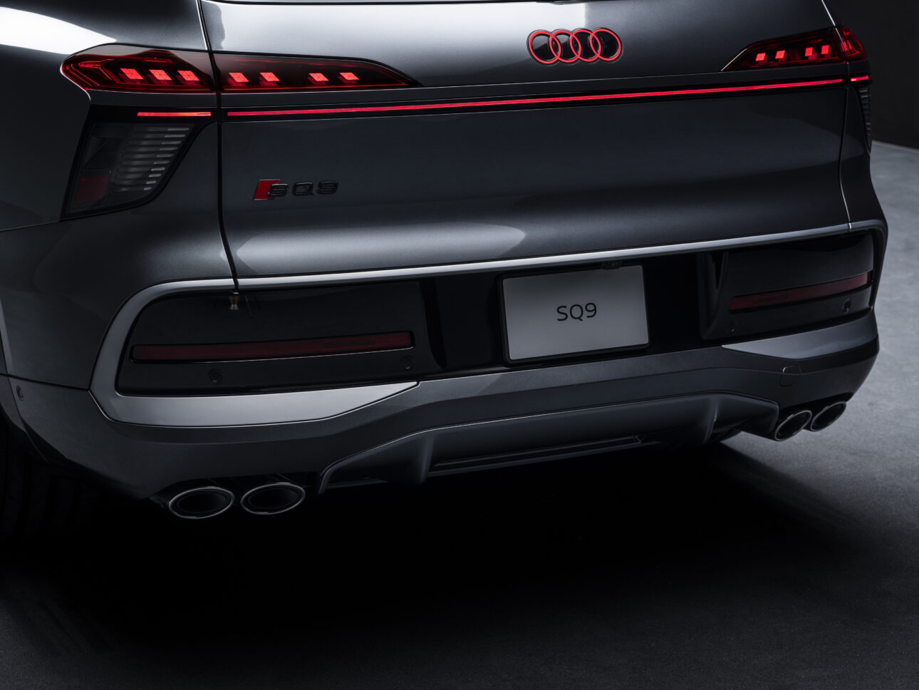 Audi SQ9 on-location Audi SQ9 tagaosa detailvaade koos valgustatud Audi logo, SQ9 märgise ja neliksummutiga