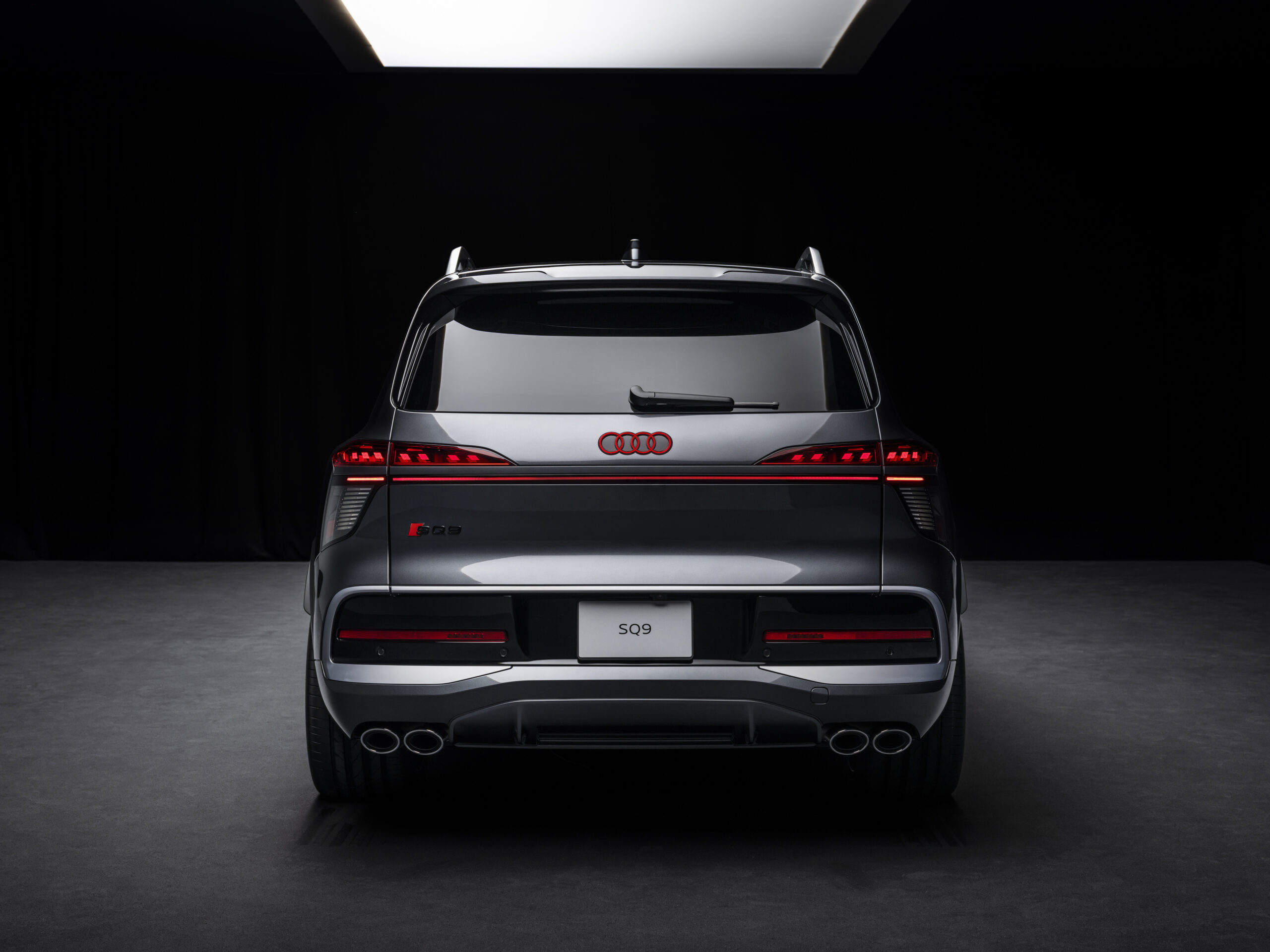 Audi SQ9 tagaosa otsevaates stuudiovalguses koos valgustatud Audi logo ja SQ9 tähisega