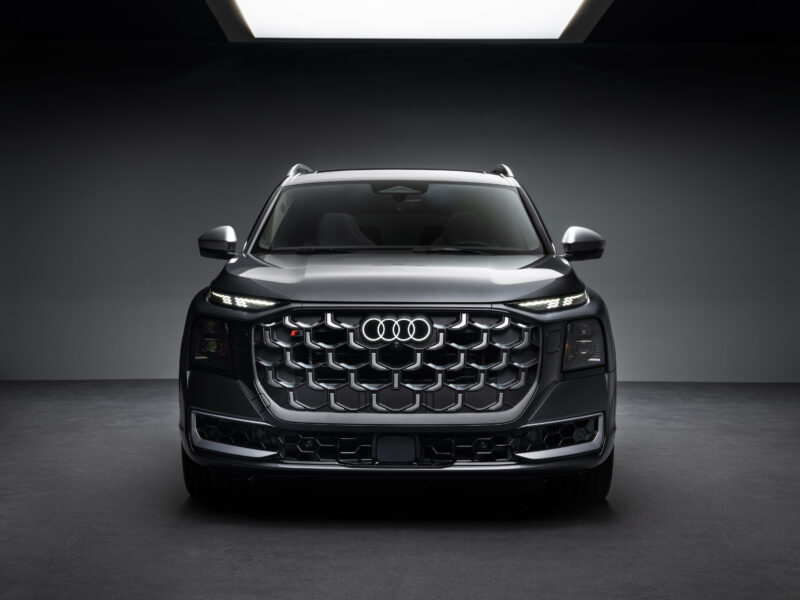 Audi SQ9 esiosa otsevaates stuudiovalguses koos valgustatud Audi logoga