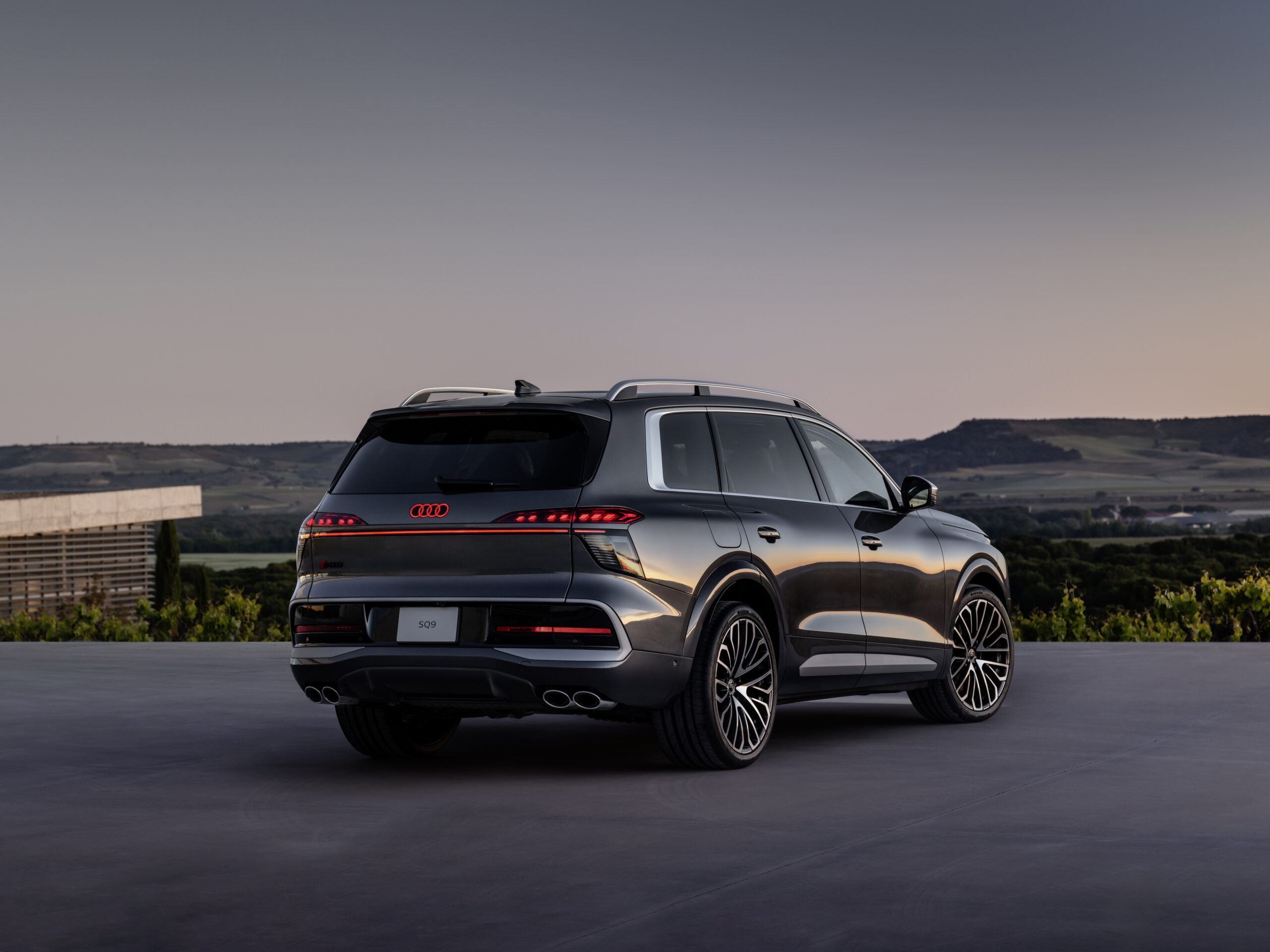 Tumehall Audi SQ9 tagumine külgvaade pargitud avatud terrassile päikeseloojangul