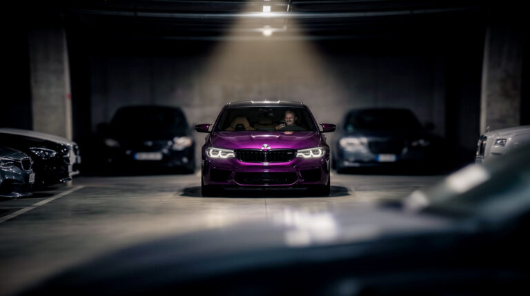 Lilla BMW M5 F90 sportauto hämaras maa-aluses parklas