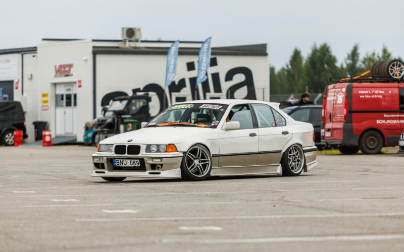Valge madaldatud kahetoonilise kerekomplektiga BMW E36 sedaan driftiauto sõitmas Porsche Ringi boksiteel Augustfest 2026 festivalil