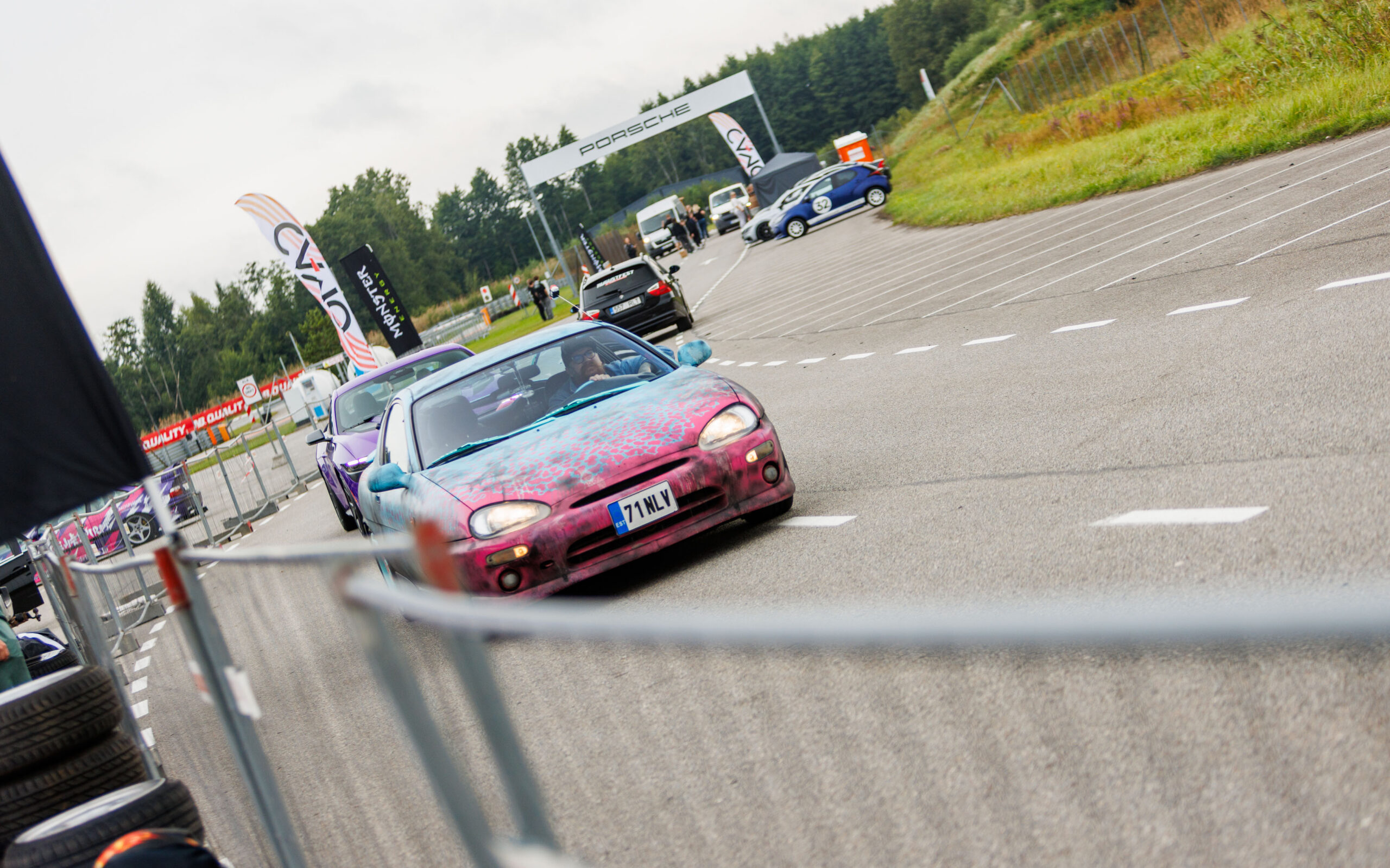 Kirju custom-värvkattega Mazda MX-3 sportkupee sõitmas Porsche Ringi rajal Monster Energy lippude vahel Augustfest 2026 autofestivalil