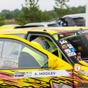 Tehnik kollases helkurvestis ette valmistamas kollast BMW E36 PRO2 driftiautot võistlussõiduks Porsche Ringi paddock-alal Augustfest 2026 festivalil