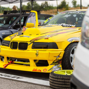 Kollane BMW E36 driftiauto laiendatud kere ja Shell Helix kleepsudega Porsche Ringi hooldustelgis Augustfest 2026 festivalil
