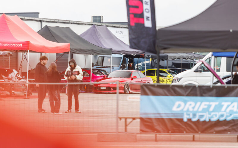 Punane madaldatud Toyota Soarer või Lexus SC driftiauto meeskonnatelkide ees Porsche Ringi paddock-alal Augustfest 2026 festivalil