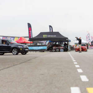 Must BMW X5 maastur seismas Porsche Ringi boksiteel Monster Energy Drift Taxi ala ja fotograafi ees Augustfest 2026 festivalil