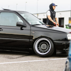 Must madaldatud Volkswagen Golf MK3 universaal katuseluugi, toonitud klaaside ja laiade terasvelgedega Porsche Ringi boksiteel Augustfest 2026 festivalil