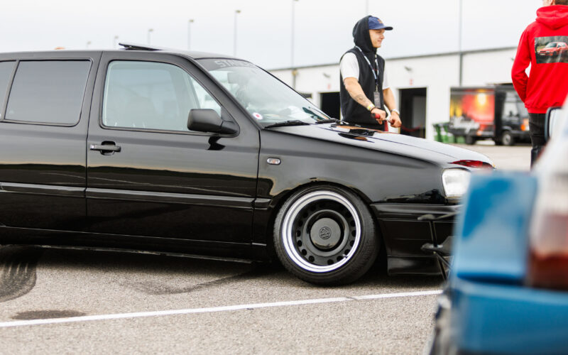 Must madaldatud Volkswagen Golf MK3 universaal katuseluugi, toonitud klaaside ja laiade terasvelgedega Porsche Ringi boksiteel Augustfest 2026 festivalil