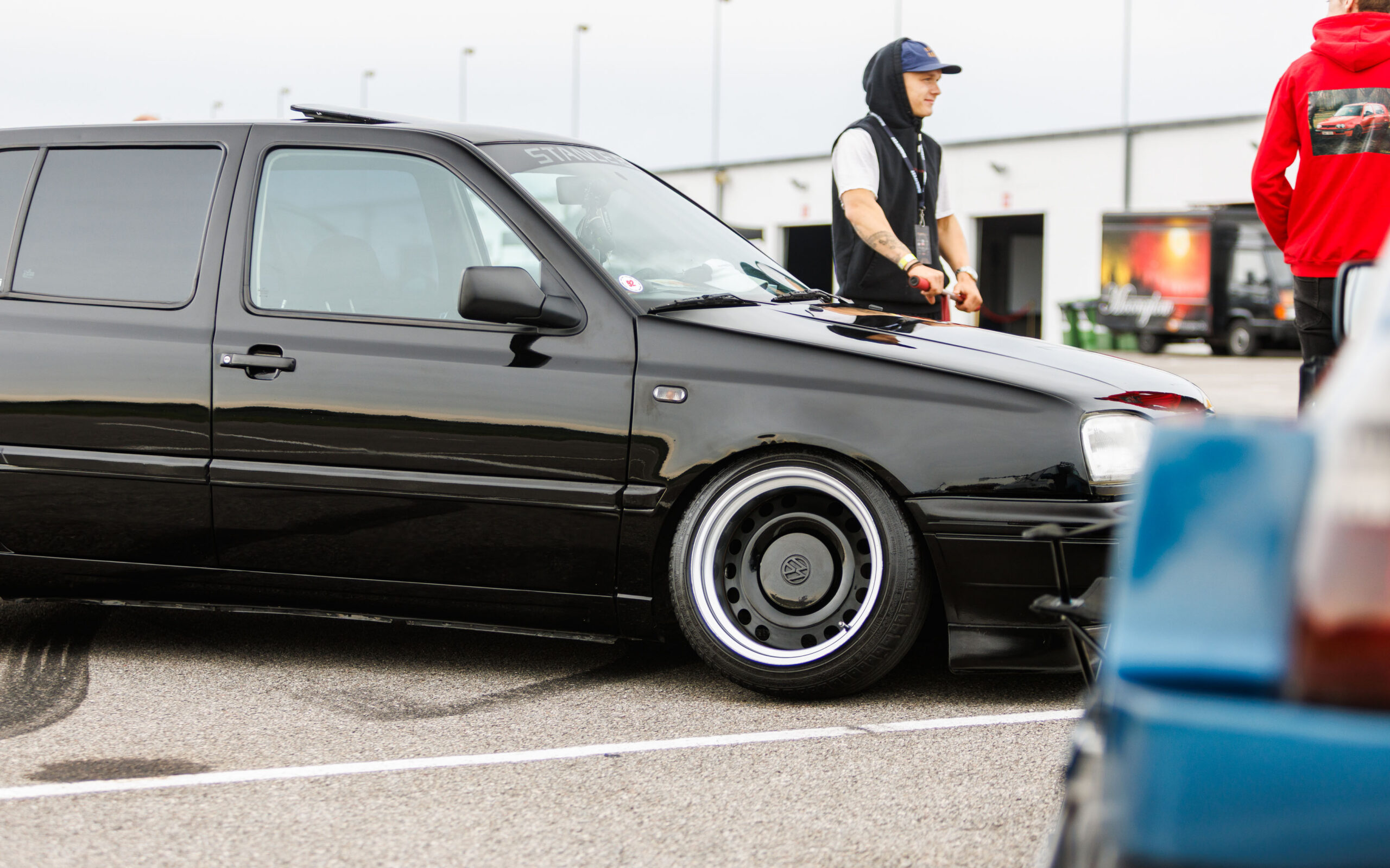Must madaldatud Volkswagen Golf MK3 universaal katuseluugi, toonitud klaaside ja laiade terasvelgedega Porsche Ringi boksiteel Augustfest 2026 festivalil