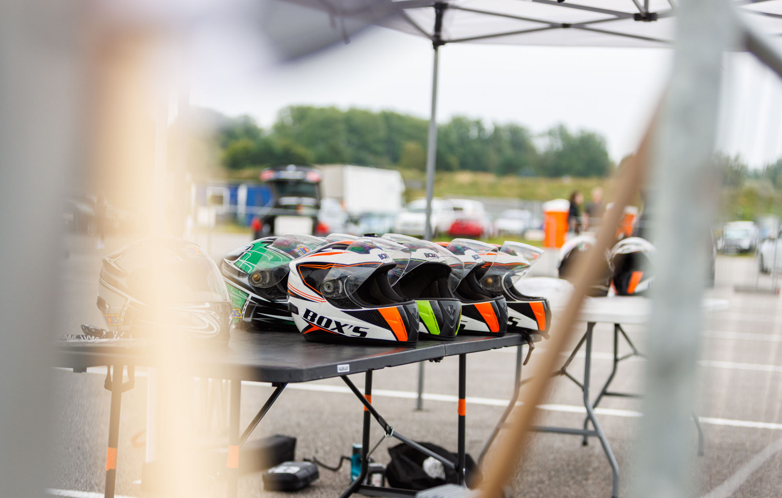 Rivi motokiivreid ja rajakiivreid laual Porsche Ringi telgi all Augustfest 2026 festivalil