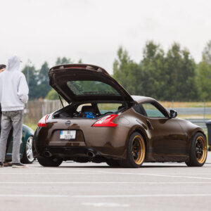 Pronkspruun madaldatud Nissan 370Z sportauto avatud tagaluugi ja kuldse randiga valuvelgedega Porsche Ringi näitusealal Augustfest 2026 festivalil