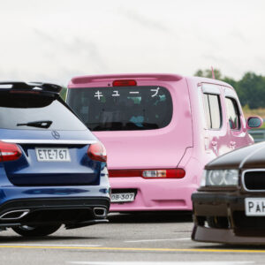 Sinine madaldatud Mercedes-Benzi universaal, roosa Nissan Cube jaapani kirjadega ja pruun BMW E36 seismas Porsche Ringi näitusealal Augustfest 2026 festivalil