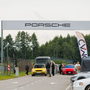 Projektiautode ja külastajate kolonn sisenemas Porsche Ringi suure Porsche portaali alt Augustfest 2026 festivalile Pärnus