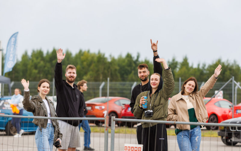 Rõõmsad noored pealtvaatajad piirdeaia taga kaamerasse lehvitamas ja käemärke tegemas Pärnu Porsche Ringil Augustfest 2026 festivalil