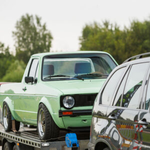 Piparmündiroheline madaldatud Volkswagen Caddy Mk1 pikap kärgvelgedega autotreileril seismas Pärnu Porsche Ringil Augustfest 2026 festivalil