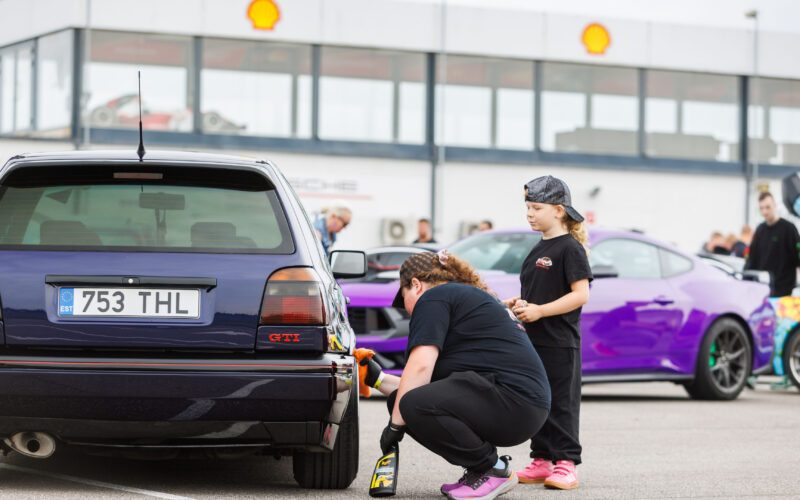 Ema ja laps puhastamas lilla Volkswagen Golf GTI tagavelge ja rehvi Pärnu Porsche Ringil Augustfest 2026 festivalil