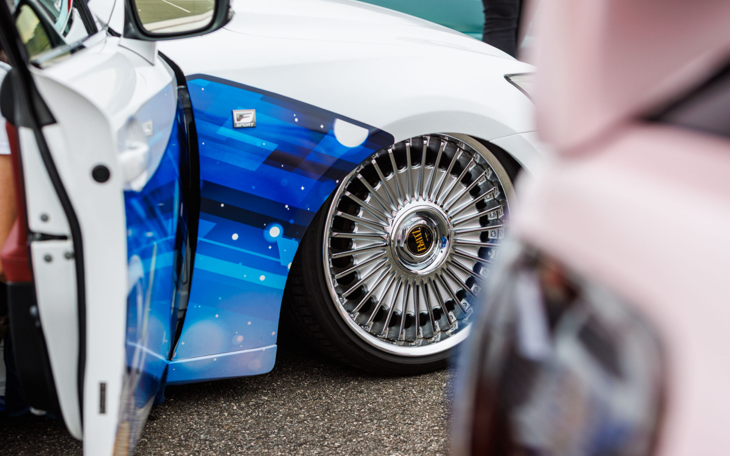 Madaldatud valge Lexus F Sport sinise kujunduskile ja mitmekodaraliste kroomitud Work Emitz velgedega Pärnu Porsche Ringil Augustfest 2026 festivalil
