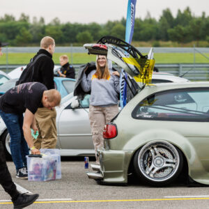 Madaldatud helehall tuuningauto avatud tagaluugi, tiibukse ja kolme kodaraga velgedega näitusealal Pärnu Porsche Ringil Augustfest 2026 festivalil