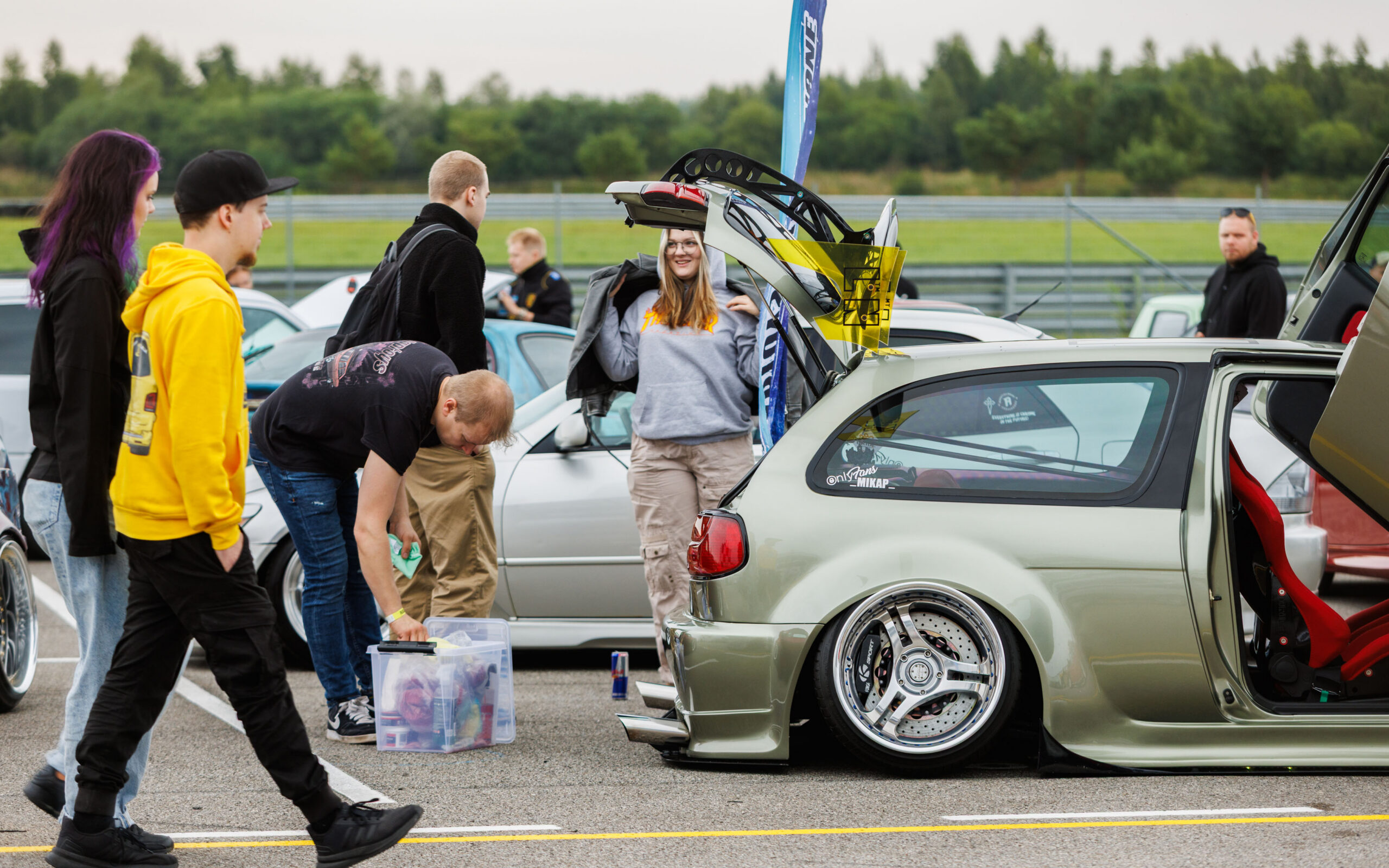 Madaldatud helehall tuuningauto avatud tagaluugi, tiibukse ja kolme kodaraga velgedega näitusealal Pärnu Porsche Ringil Augustfest 2026 festivalil