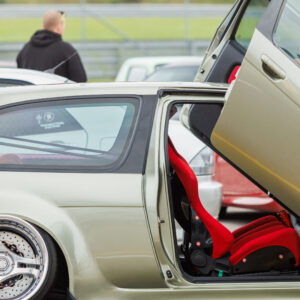Tuunitud madaldatud helehall luukpära ülesavaneva lambo-ukse, punase korvistme ja kolme kodaraga kroomvelgedega Pärnu Porsche Ringil Augustfest 2026 festivalil