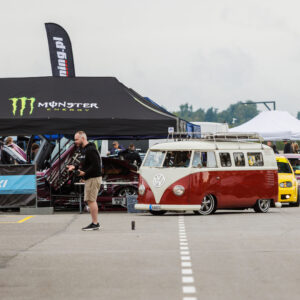 Madaldatud punane ja valge Volkswagen T1 buss ning autode kolonn Monster Energy ja Drift Taxi telkide ees Pärnu Porsche Ringil Augustfest 2026 festivalil