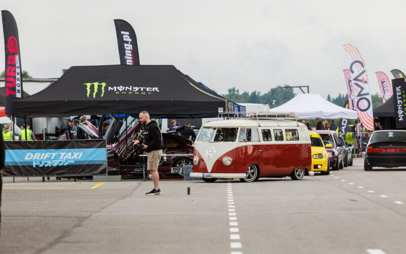 Madaldatud punane ja valge Volkswagen T1 buss ning autode kolonn Monster Energy ja Drift Taxi telkide ees Pärnu Porsche Ringil Augustfest 2026 festivalil
