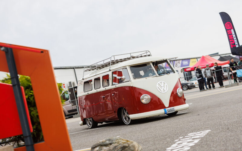 Madaldatud punane ja valge klassikaline Volkswagen T1 buss katuseraamiga sõitmas Pärnu Porsche Ringil Augustfest 2026 festivalil