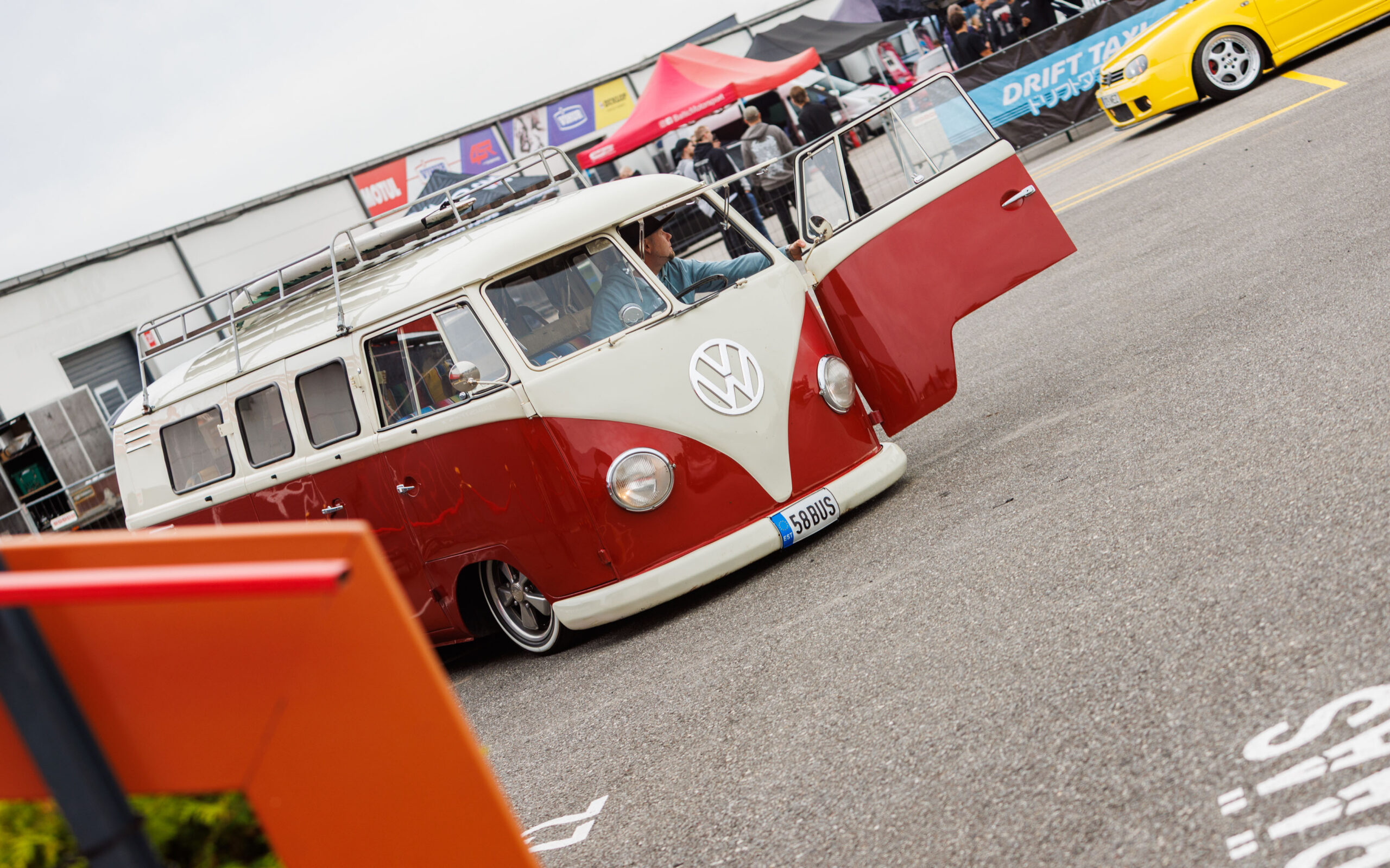Madaldatud punase ja valge värvikombinatsioonis klassikaline Volkswagen T1 buss katuseraamiga ja avatud uksega Pärnu Porsche Ringil Augustfest 2026 festivalil
