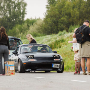 Must madaldatud Mazda MX-5 Miata läbimas piletikontrolli ja rahvamassi Augustfest 2026 festivali sissepääsus Pärnu Porsche Ringil