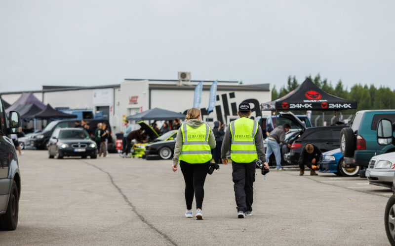 Meediameeskonna liikmed helkurvestides kõndimas Pärnu Porsche Ringi boksiteel Augustfest 2026 festivalil