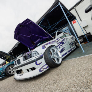 Valge BMW E36 driftiauto lillade leekide ja avatud lilla kapotialusega boksis Pärnu Porsche Ringil Augustfest 2026 festivalil