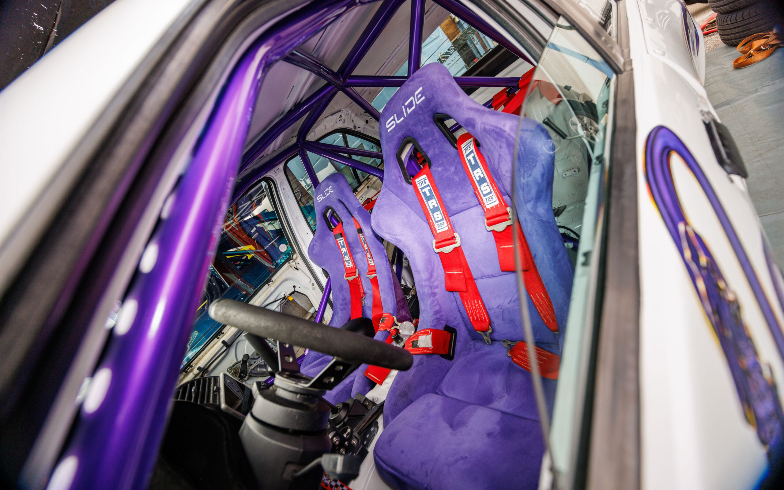 Driftiauto kergendatud salong lilla turvapuuri, violetsete Slide korvistmete ja punaste TRS traksrihmadega Pärnu Porsche Ringil Augustfest 2026 festivalil