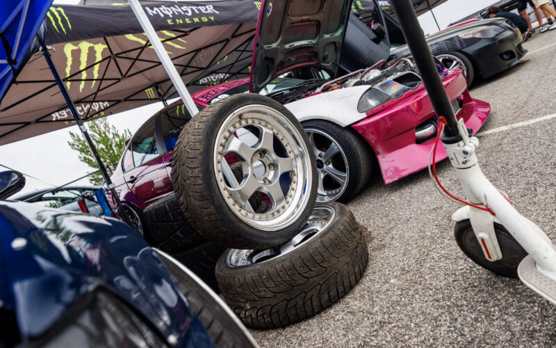 Driftiauto varurattad esiplaanil ja avatud kapotiga roosa BMW E36 driftiauto Monster Energy telgi all Pärnu Porsche Ringil Augustfest 2026 festivalil
