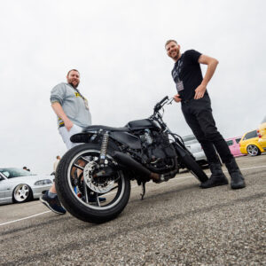 Kaks meest poseerimas custom musta cafe racer mootorratta kõrval Pärnu Porsche Ringil Augustfest 2026 festivalil