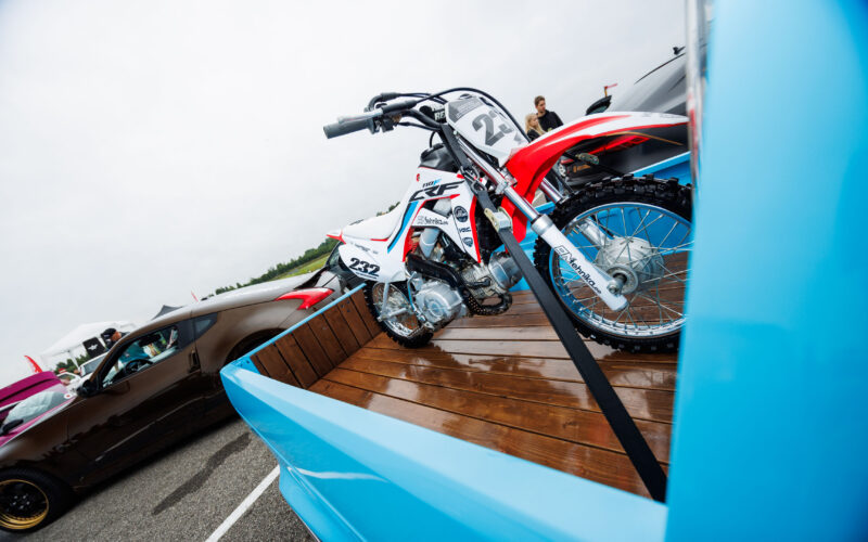 Helesinise kastiauto puidust kastis rihmadega kinnitatud punane-valge Honda CRF krossimootorratas Pärnu Porsche Ringil Augustfest 2026 festivalil