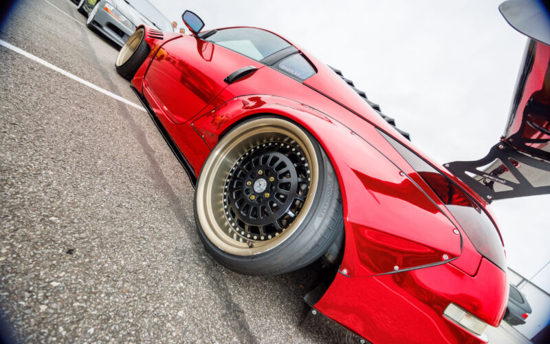 Läikivpunane kroomviimistlusega laiendatud tagatiivaga Nissan 350Z mitmeosalise kuldse randiga valuveljega Pärnu Porsche Ringil Augustfest 2026 festivalil