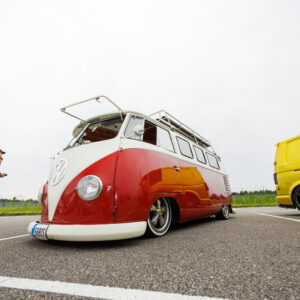 Madaldatud punane ja valge klassikaline Volkswagen T1 buss katuseraami ning lahtikäivate Safari akendega Pärnu Porsche Ringil Augustfest 2026 festivalil