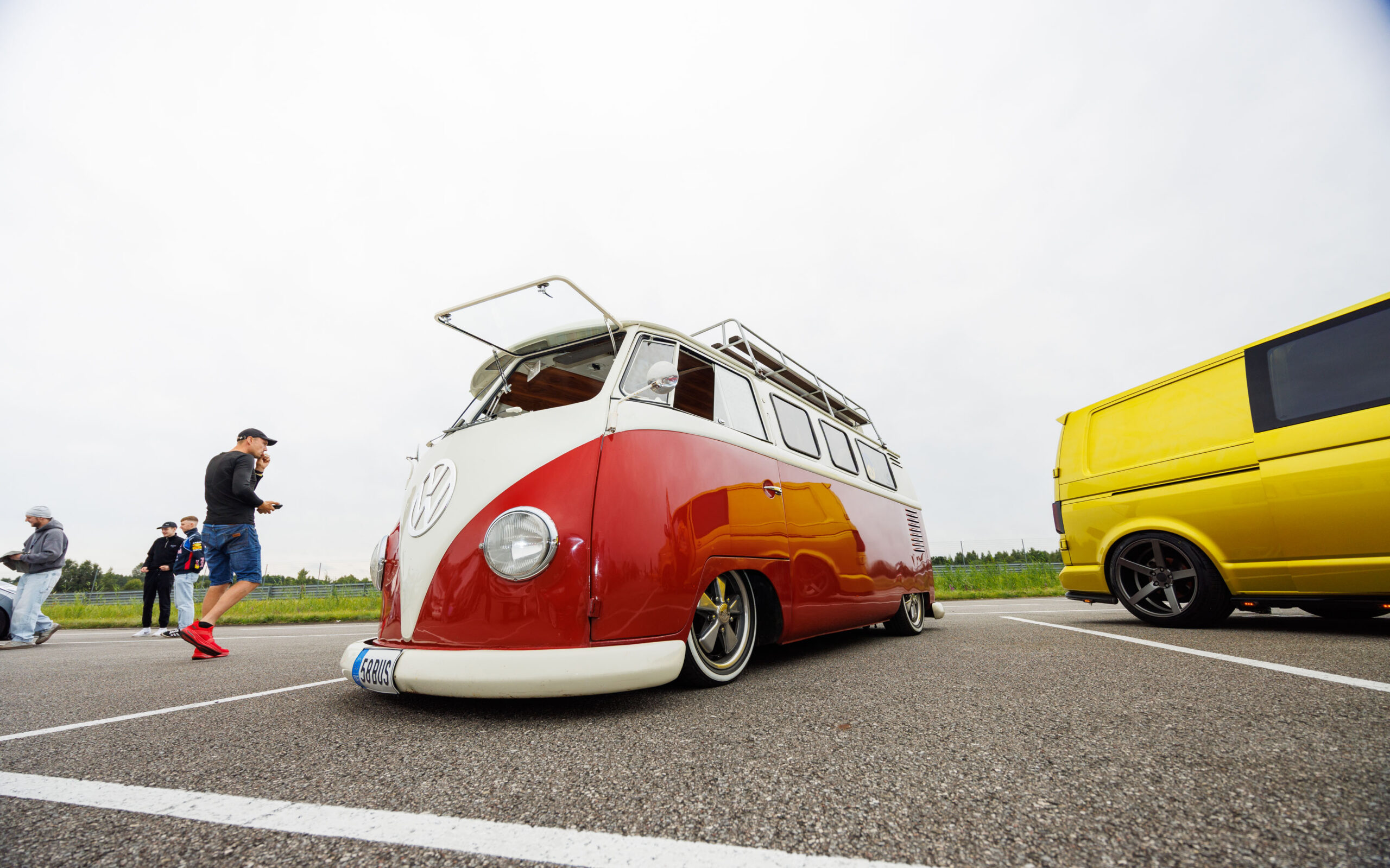 Madaldatud punane ja valge klassikaline Volkswagen T1 buss katuseraami ning lahtikäivate Safari akendega Pärnu Porsche Ringil Augustfest 2026 festivalil
