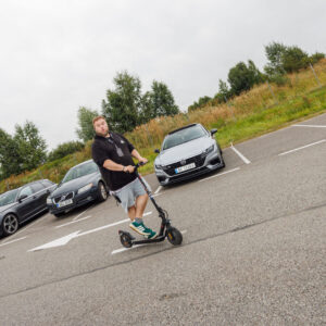 Mees elektritõukerattaga sõitmas parklas pargitud autode ees Pärnu Porsche Ringil Augustfest 2026 festivalil