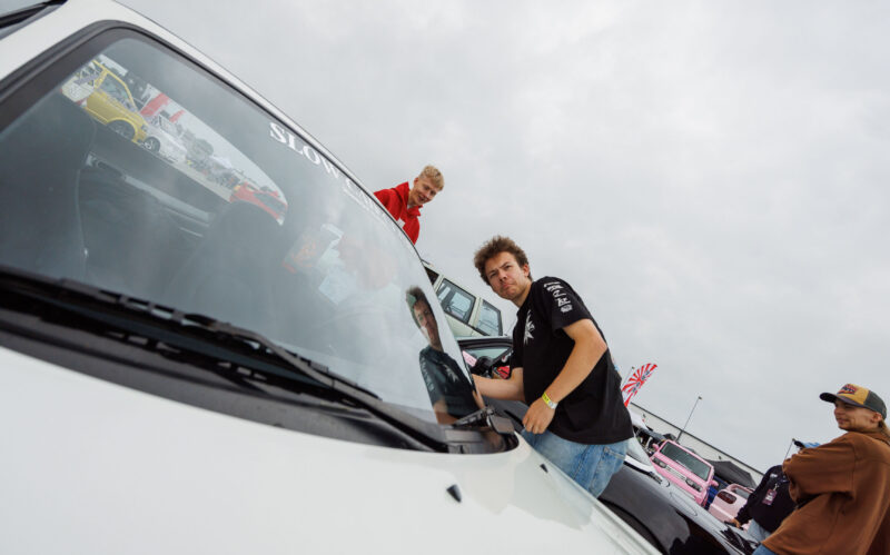 Noored autohuvilised uurimas valget tuunitud autot Pärnu Porsche Ringi parklas Augustfest 2026 festivalil