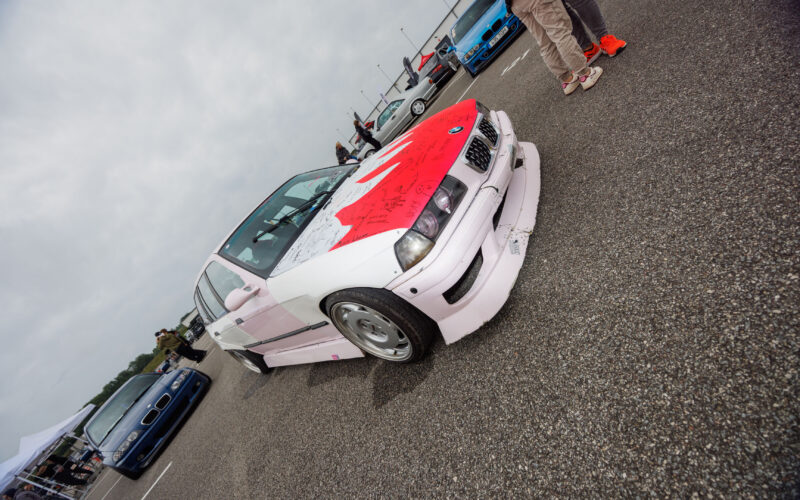 Madaldatud roosakasvalge BMW E36 sedaan autogrammidega kaetud kapotiga Pärnu Porsche Ringi parklas Augustfest 2026 üritusel