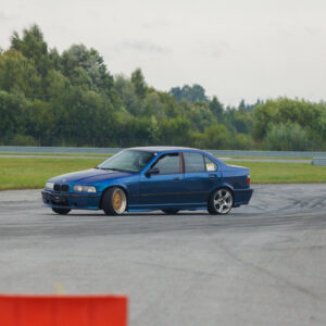 Sinine madaldatud BMW E36 sedaan driftiauto driftimas Porsche Ringi rajal Augustfest 2026 festivalil
